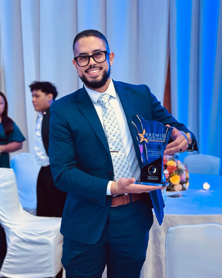El Dr. Steve Henríquez sostiene el Premio a la Excelencia Empresarial